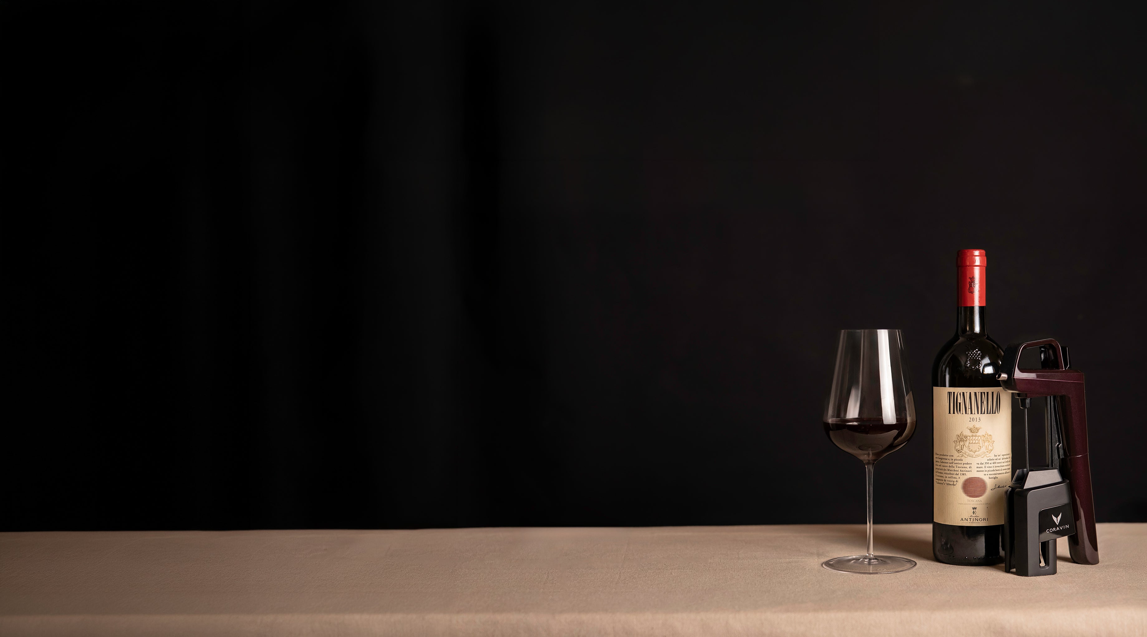 Wine bottle, glass, and decanter on a dark background
